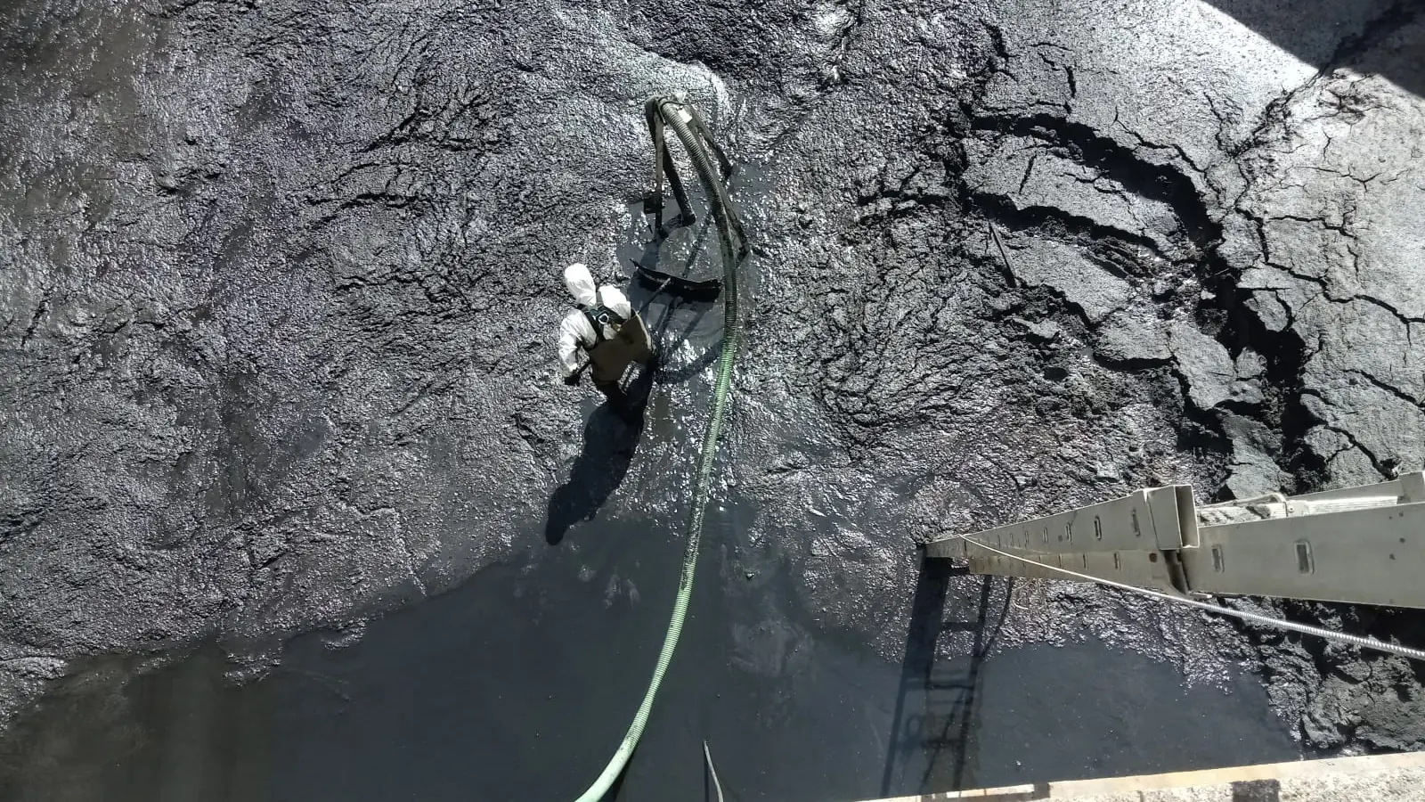 Técnico trabajando dentro de un depósito durante su revestimiento